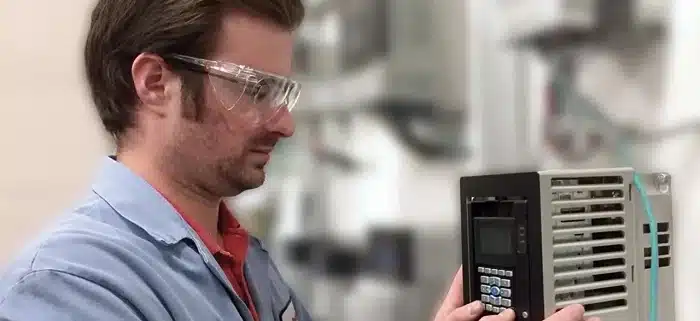 Technician verifying VFD parameter settings for motor current and overload