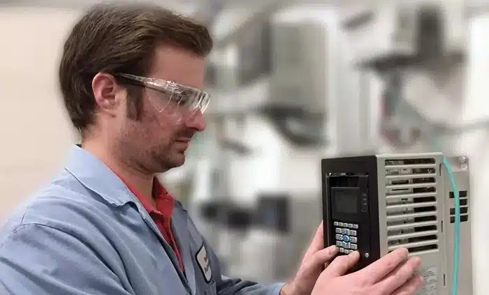 Technician verifying VFD parameter settings for motor current and overload