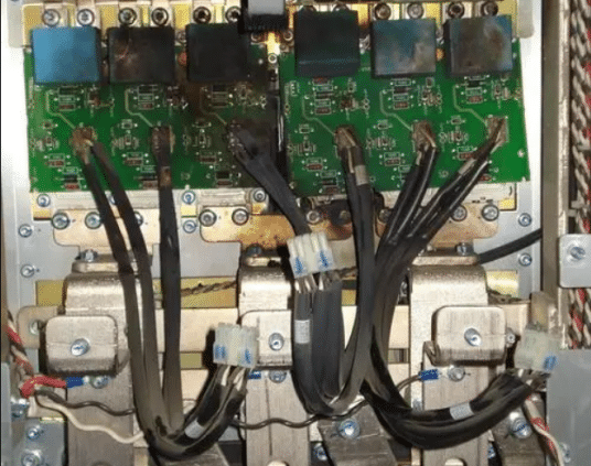 Smoke rising from a failed VFD with burn marks on internal components