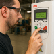 Technician scrolling a VFD programming menu on an ABB keypad